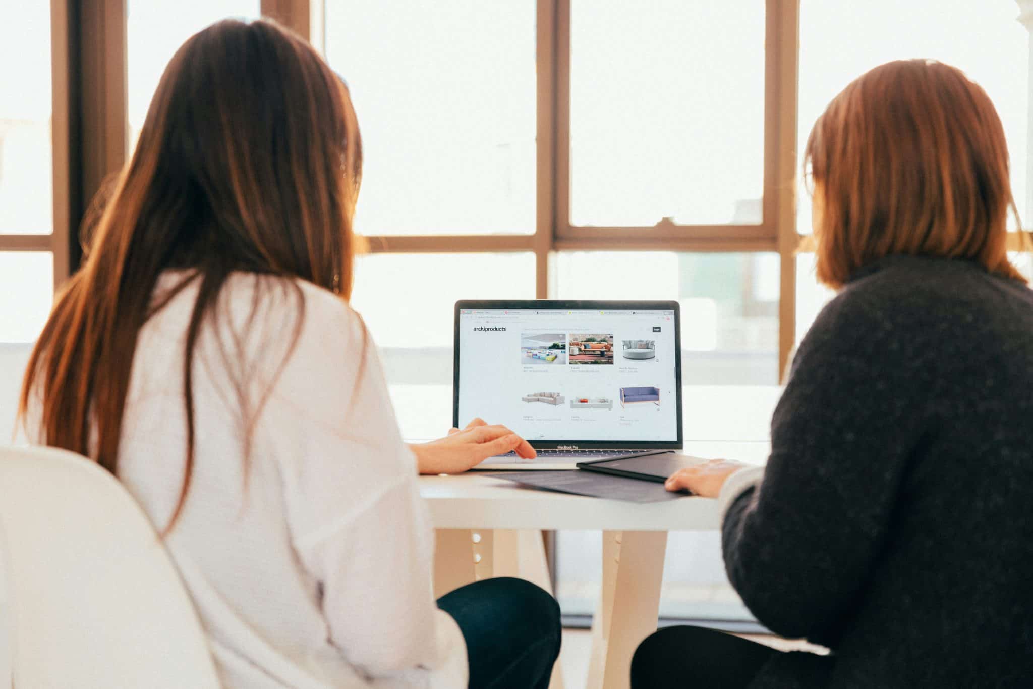 woman installing backups onto a computer with someone else watching